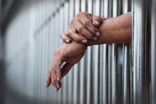 Hands through prison bars